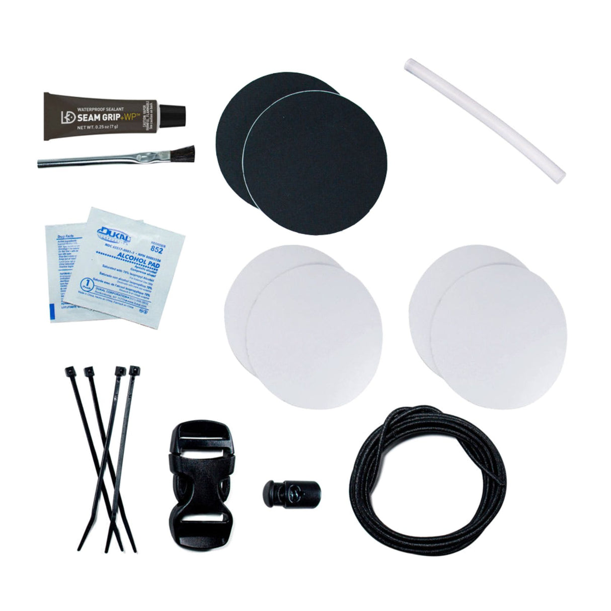 Gear Aid Tenacious Tape Camp Repair Kit Contents Laid out : 4 clear Tenacious Tape patches (7.6 cm rounds), 2 black nylon Tenacious Tape patches (7.6 cm rounds), Seam Grip WP sealant (7g), applicator brush, two alcohol wipes, one hot melt stick, four zip ties, 25mm Dual-Adjust Buckle, Ellipse Cord Lock, and 2m of Shock Cord