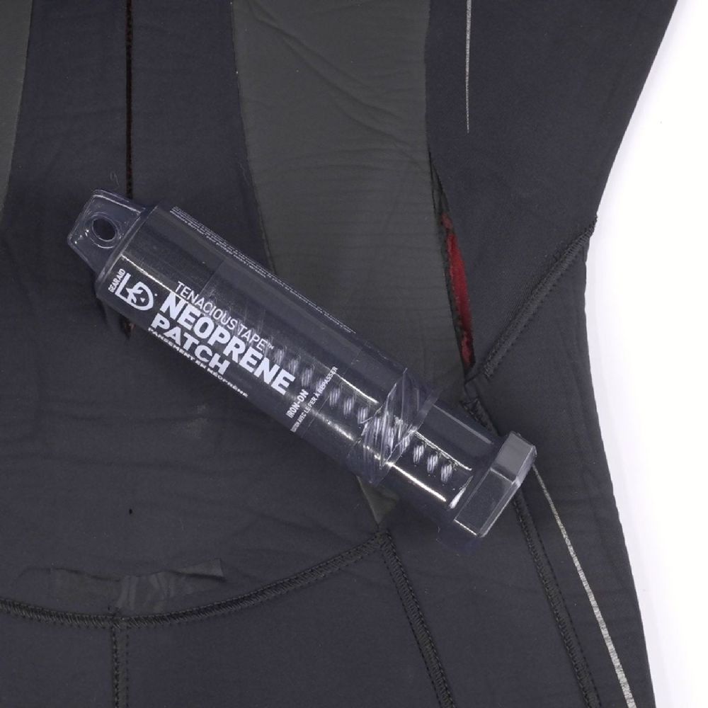 Gear Aid Tenacious Tape Neoprene Patch resting on a wetsuit with a tear in need of repair