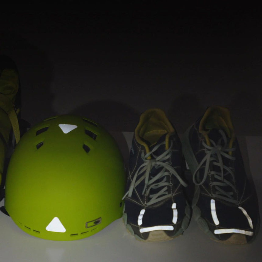 Gear Aid Reflective Tenacious Tape applied to a green safety helment and a pair of old runners