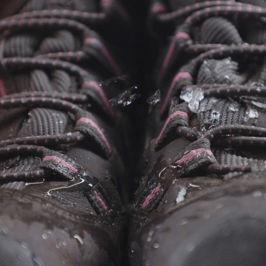 Close up of black nubuck shoes with black and purple laces demonstration of Waterproofing with Gear Aid Tent Water Rellent
