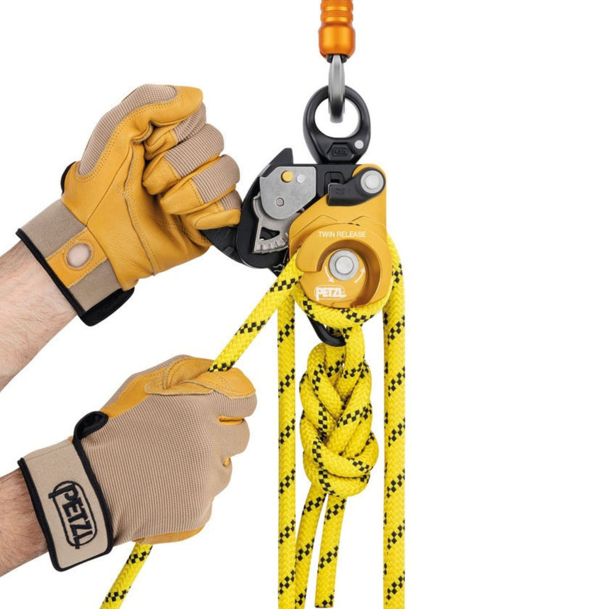 Professional demonstrating Petzl Twin Release Pulley showing release of the cam and passage of the rope through the brake integrated into the main moving side plate, which allows comfortable and precise control when lowering