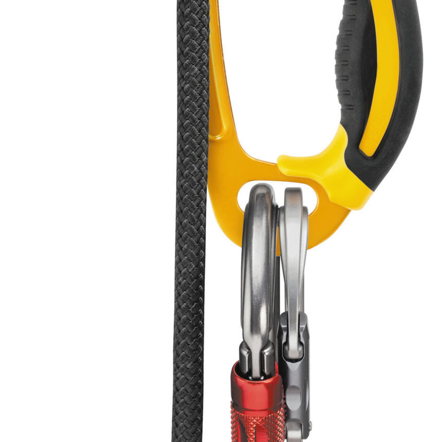 Focus on the Petzl Ascension handled rope clamp wide lower hole with the carabiners of the PROGRESS lanyard and FOOTAPE and FOOTCORD footloops attached.