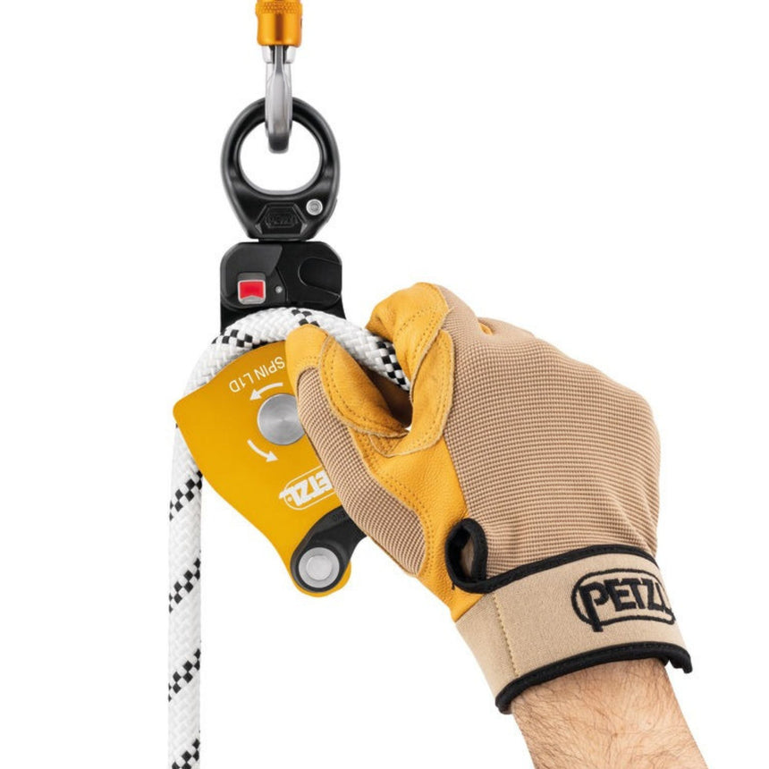 Professional wearing a glove installing a rope on the Petzl Spin L1D single pulley with one-way rotation and swivel
