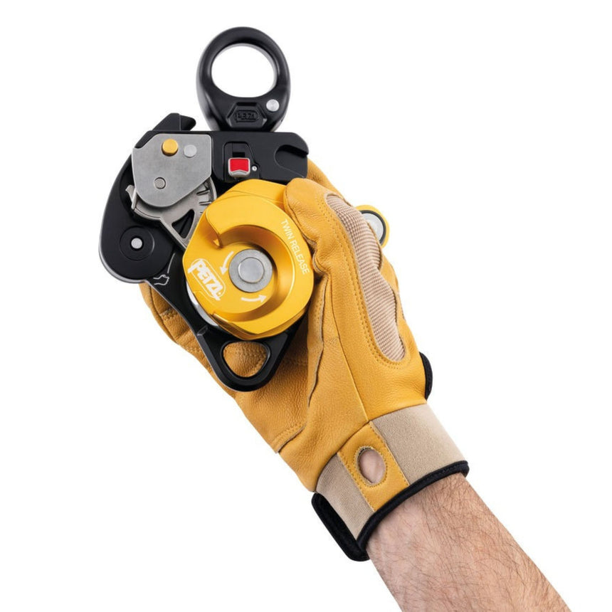 Professional wearing a glove demonstrating one handed Triple-action opening of the moving side plates on the Petzl Twin Release Pulley