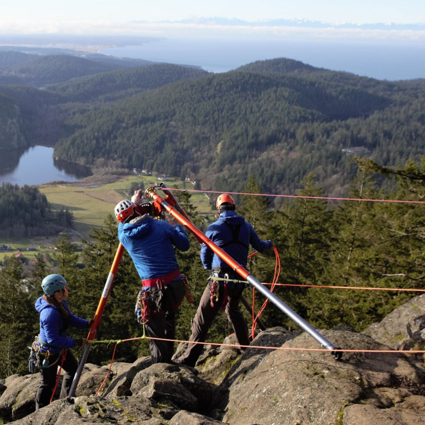 Rescue professionals using the SMC TerrAdaptor tripod system on a rocky mountain ridge during a rope rescue operation, illustrating its stability and portability.
