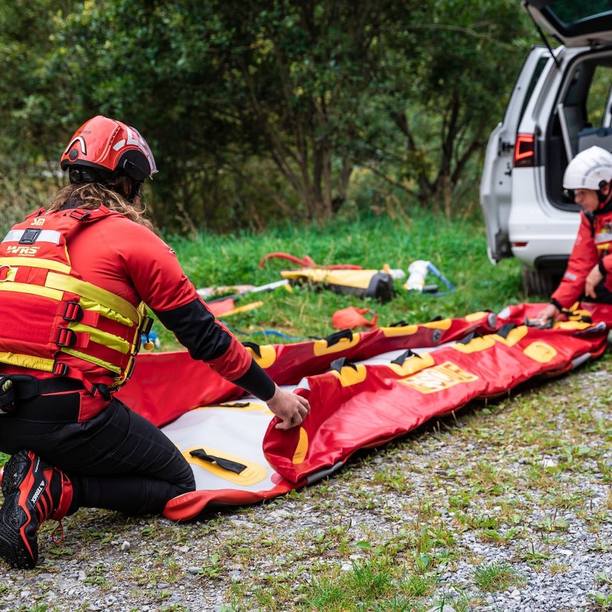 WRS Technical Rescue Helmet in red and white with external visors on models folding a rescue raft
