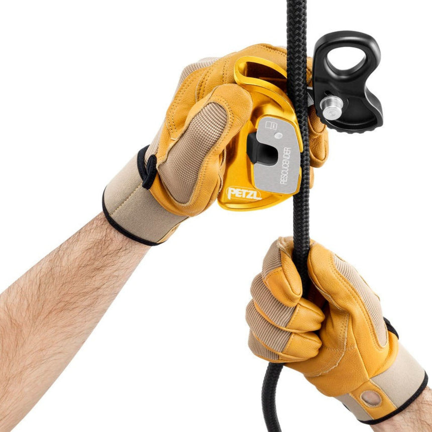 Professional wearing gloves installing a rope on the Petzl rescucender. The  openable guided cam allows easy installation or removal of the rope clamp at any point on the rope.