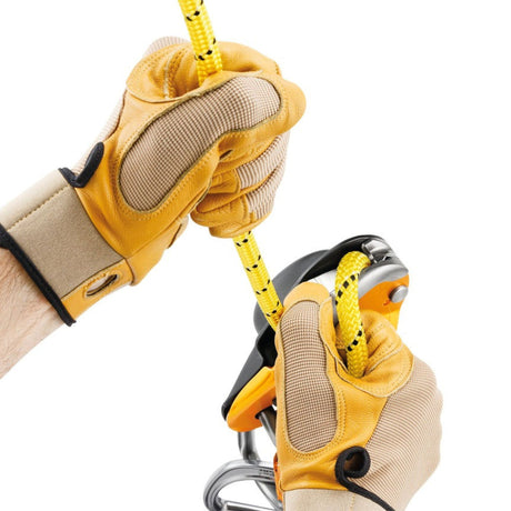 Professional wearing gloves showing the cam can be manipulated to feed out slack easily or belay a lead using climbing techniques.
