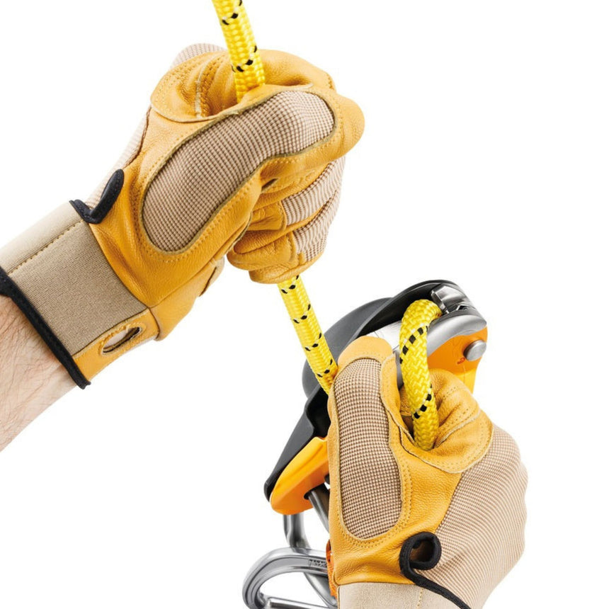 Professional wearing gloves showing the cam can be manipulated to feed out slack easily or belay a lead using climbing techniques.
