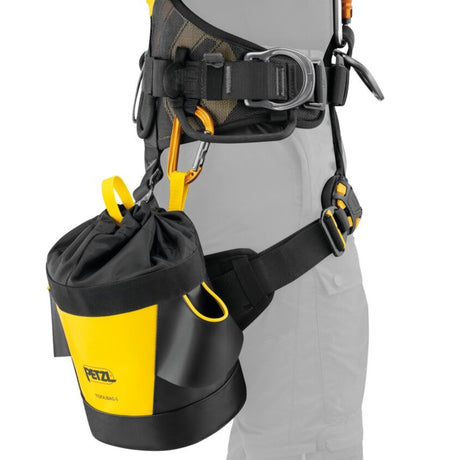 Professional demonstrating the Petzl Tool Bag 6 Tool Pouch attached to a harness with a classic carabiner